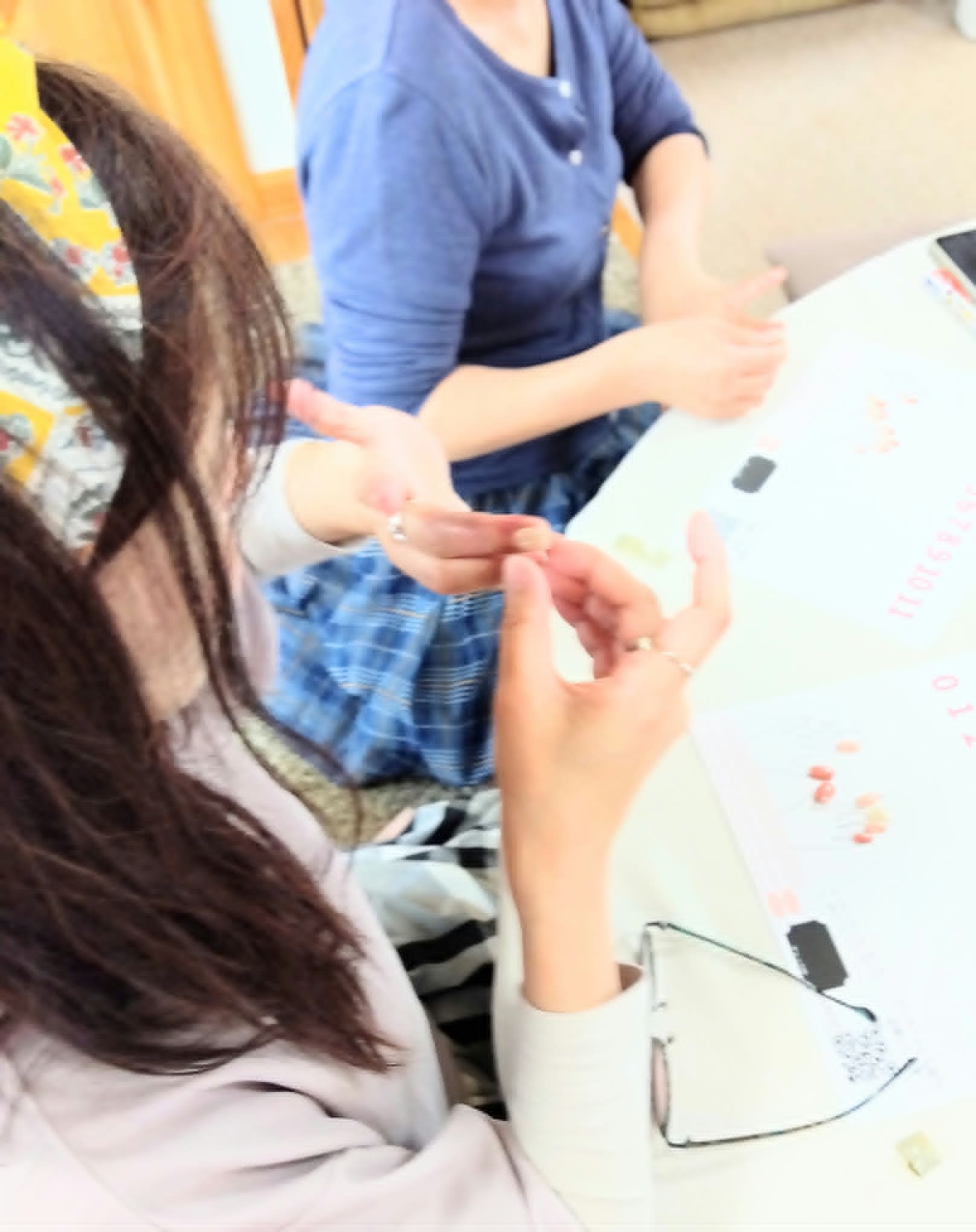 青森での対面ワークショップ。テーブルを囲んでネイルチップを付けている様子